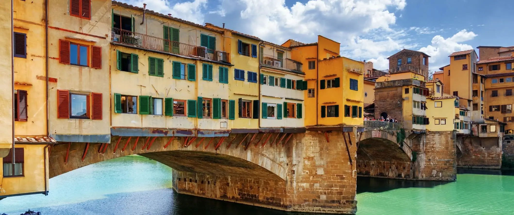 밝은 노란색의 베키오 다리(Ponte Vecchio)는 이탈리아 피렌체에 있는 중세 시대의 다리입니다.