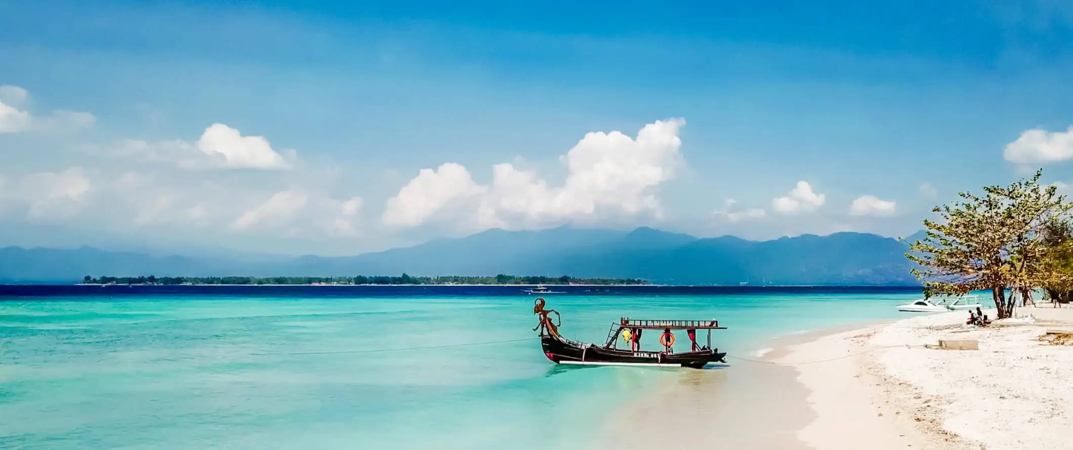 en underbar strand med en båt parkerad längs stranden på Giliöarna, Indonesien