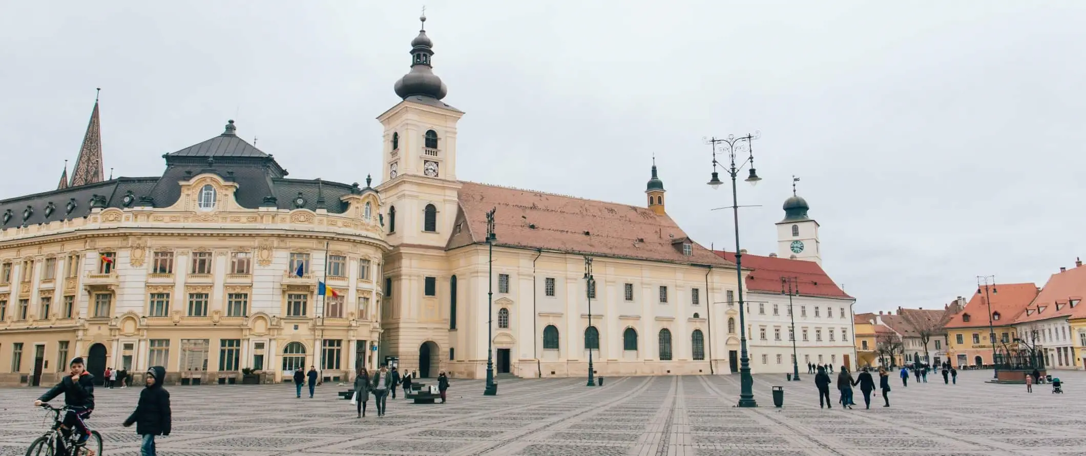 Folk går gennem en plads i den historiske gamle bydel i Sibiu, Rumænien