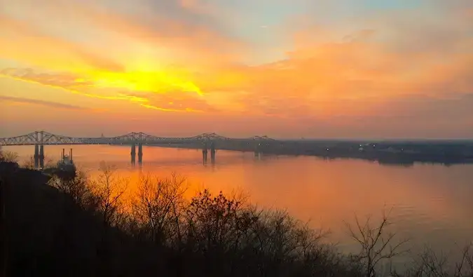 Un tramonto arancione brillante sull'acqua vicino a Natchez, Mississippi