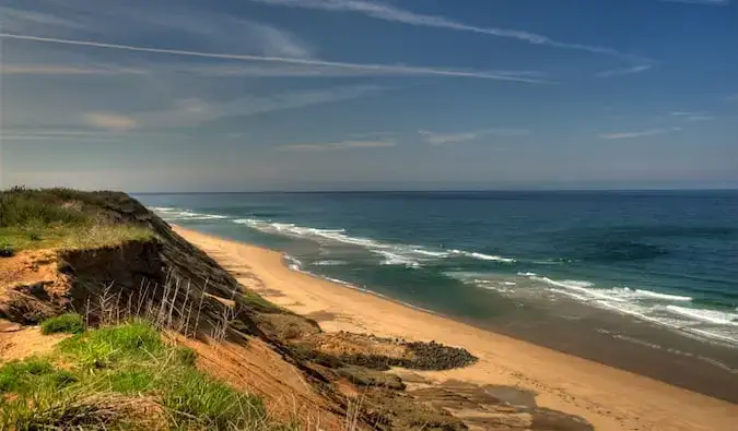 Bølger slår mot en solrik strand i Cape Cod, Massachusetts