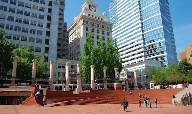 En solrik offentlig plass i Portland, Oregon med folk som går rundt